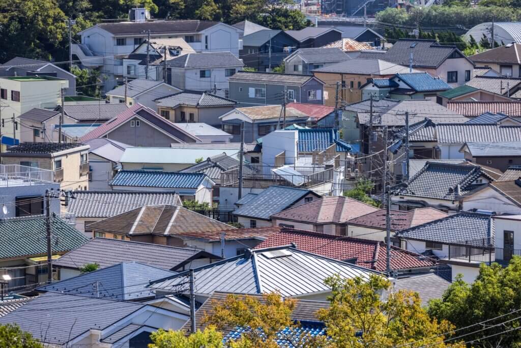 三角屋根の家が並ぶ日本の住宅街を俯瞰、青空