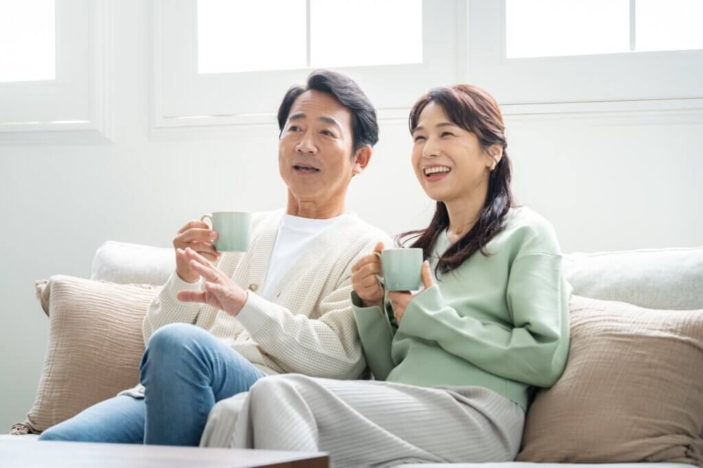 明るいリビングでくつろぐ日本人のシニア夫婦