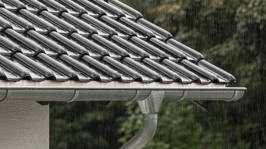 軒先を流れる雨と雨樋のクローズアップ