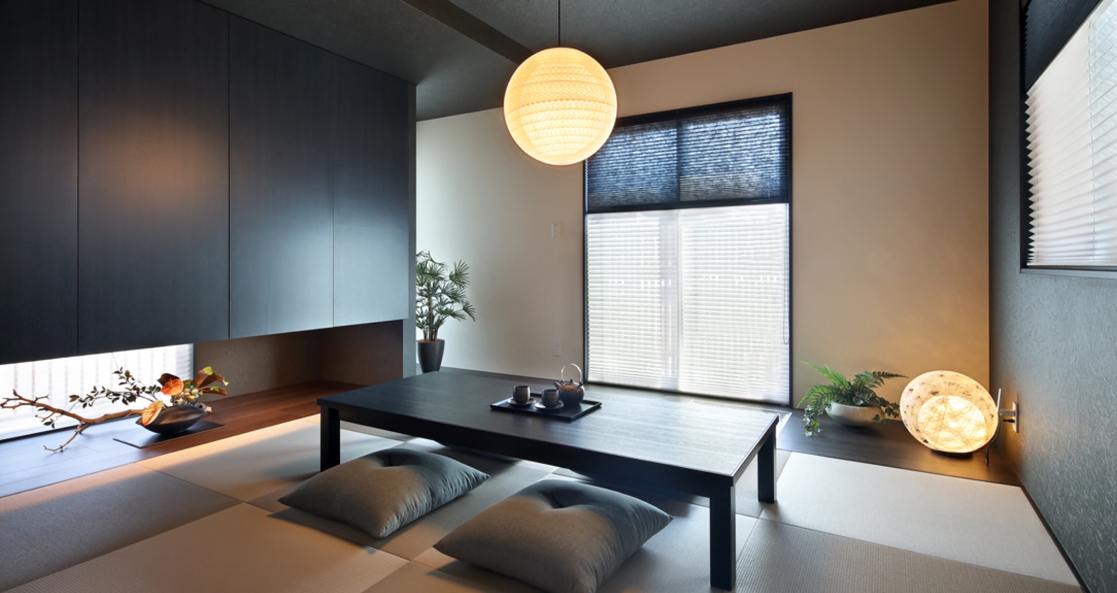 福井 家の森展示場の和室。黒い建具と丸い和紙の照明