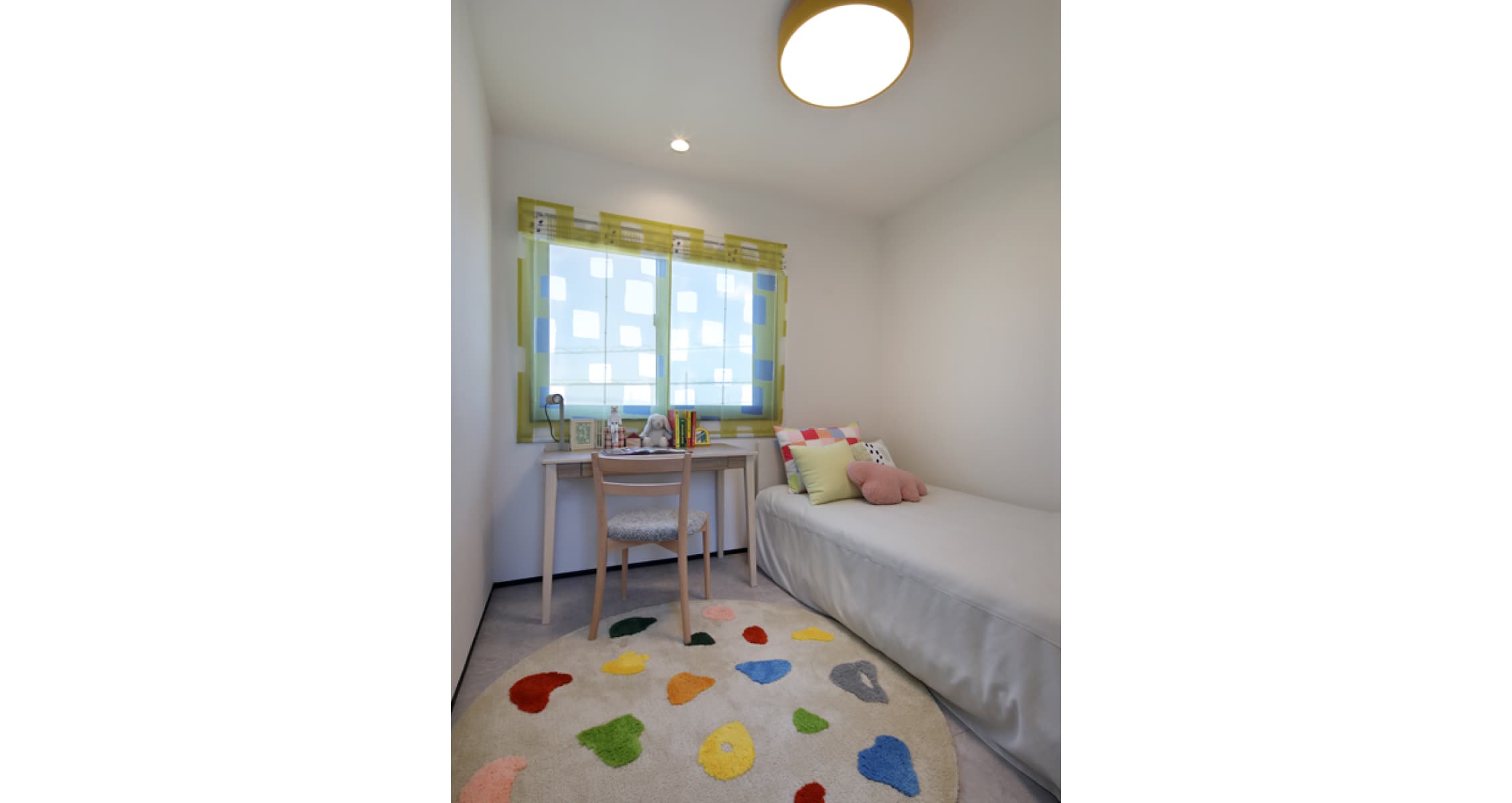 福井 家の森展示場の子供部屋。窓辺の机と色を散らしたラグ